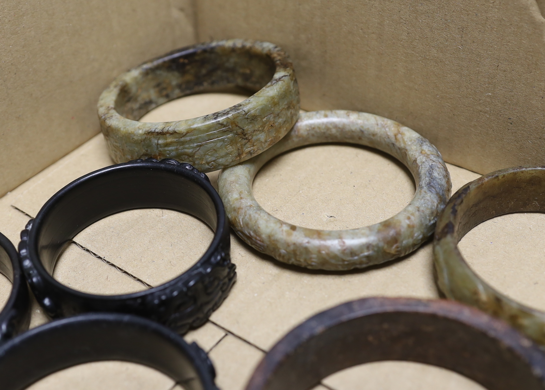 Nine assorted Chinese jade and hardstone bangles and three spheres, largest bangle 8.5cm diameter